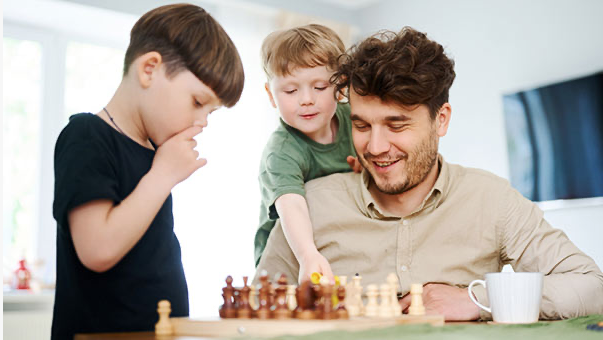 Boys playing chess with Dad